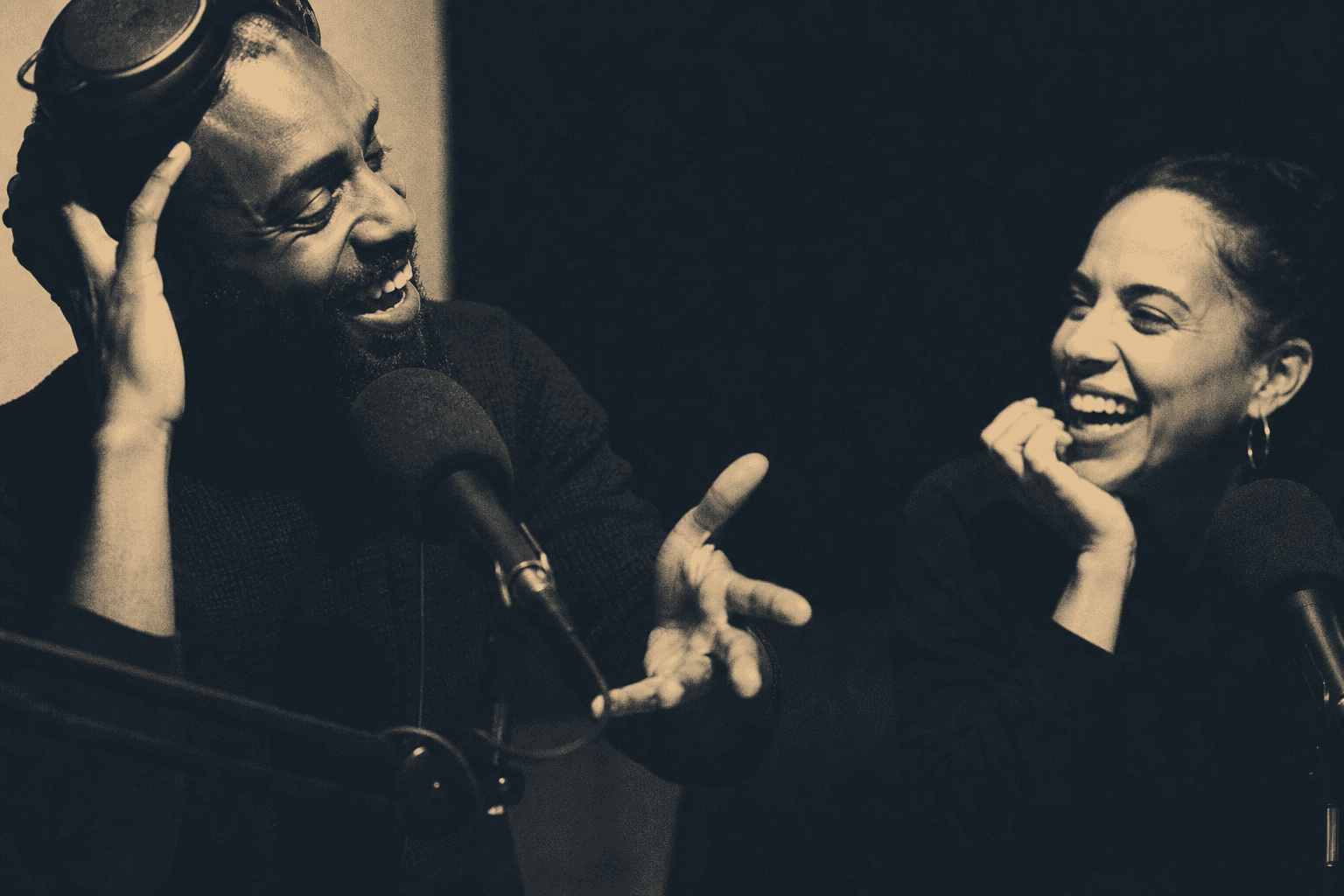 Two people recording a podcast conversation with boom microphones and headphones