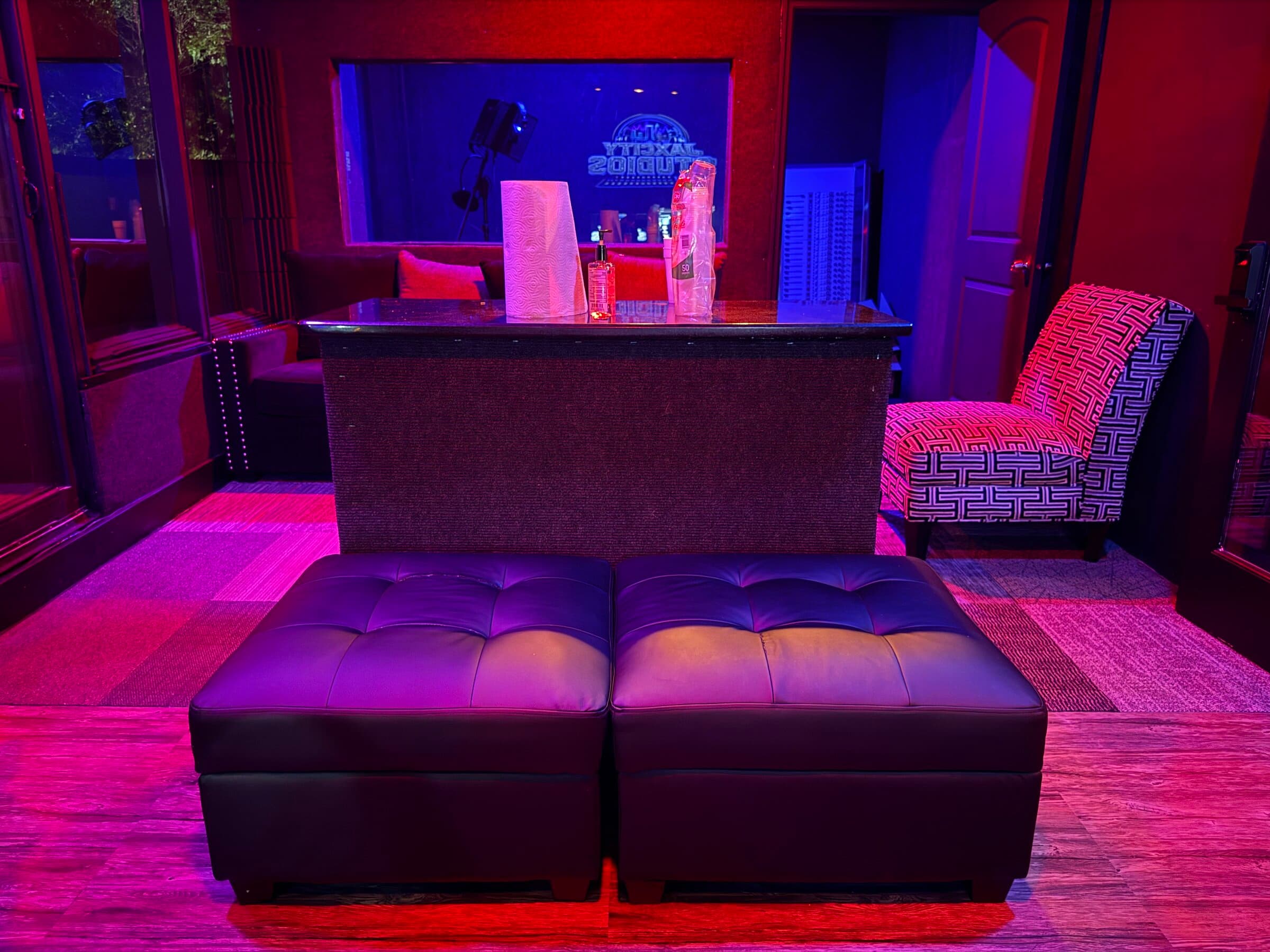 Studio lounge looking into the blue-lit recording booth