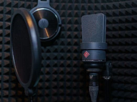 Neumann TLM 103 in the booth — pop filter and headphones ready for a take